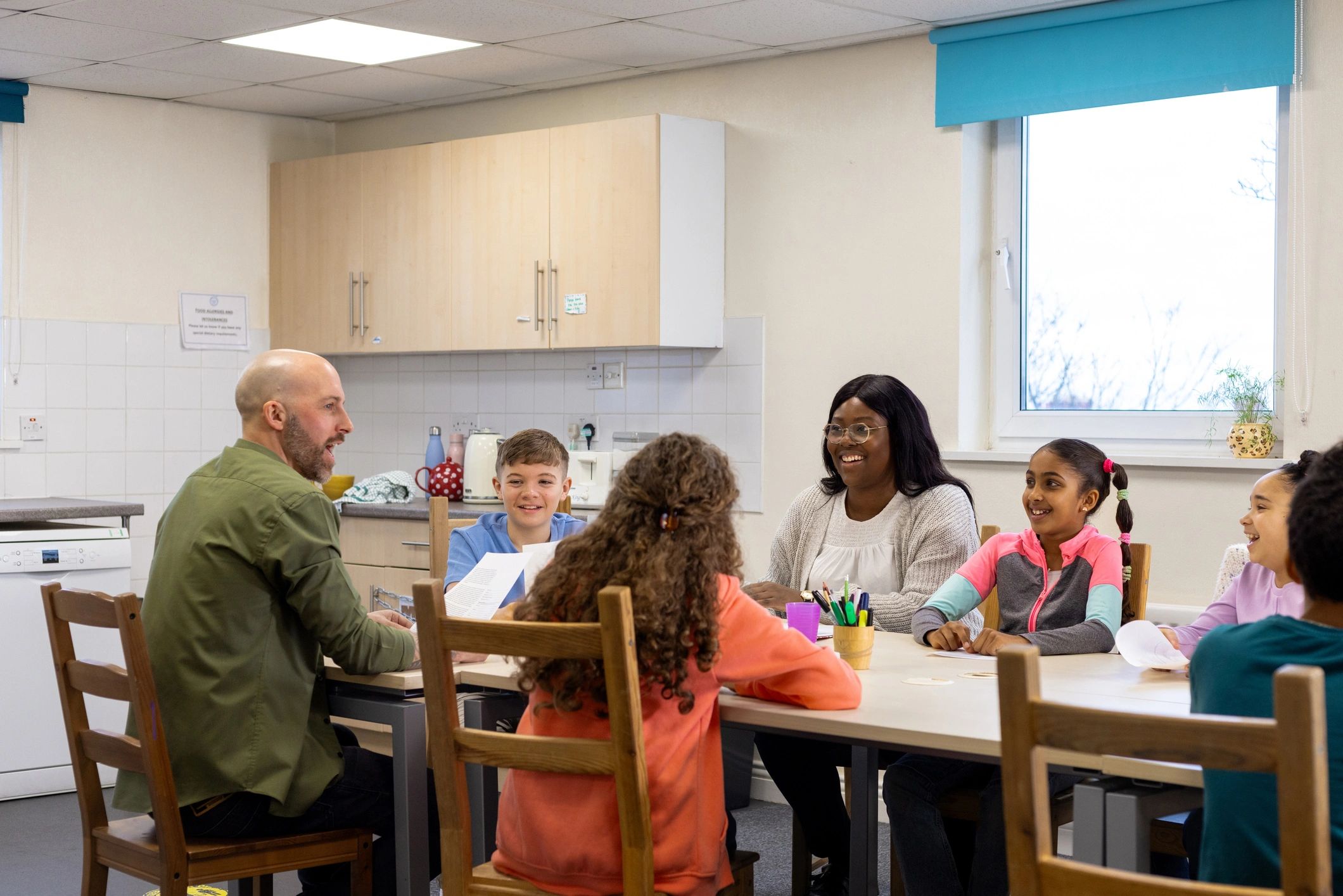 Children gathered around a table in a supportive learning setting