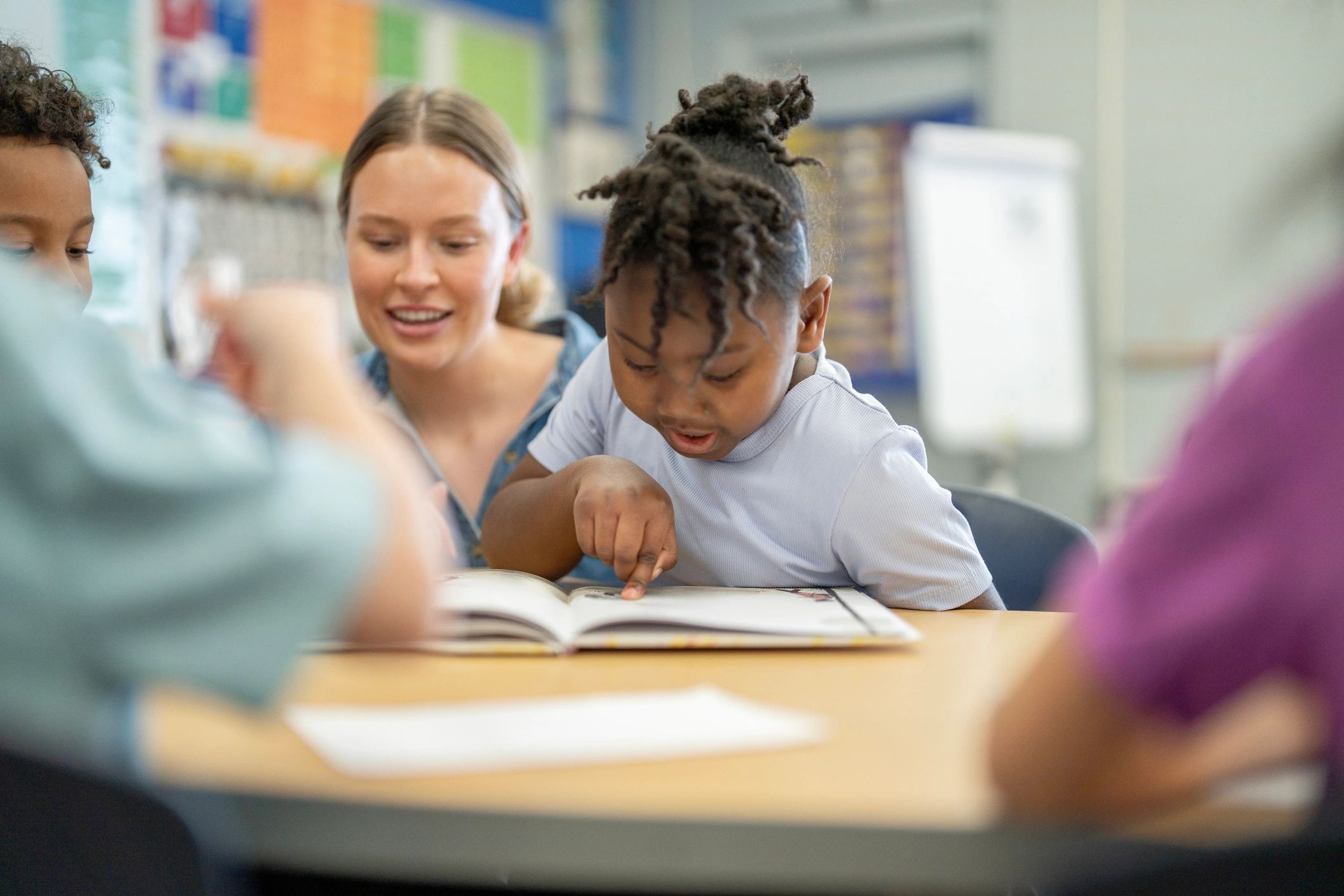 Teacher reading a picture book with young students